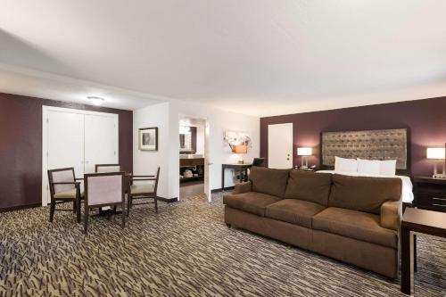 奥兰多Clarion Inn & Suites Across From Universal Orlando Resort的带沙发的客厅和卧室