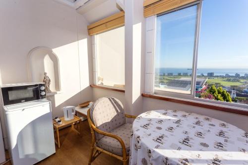 开普敦Villa Marina Guest House的客房设有床、桌子和窗户。