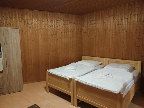 贝库姆Ruhige freistehender Bungalow mit Parkplatz的卧室配有木墙内的一张床