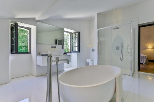 Saint-Martin-des-CombesCHATEAU DE LASCOUPS的白色的浴室设有浴缸和淋浴。