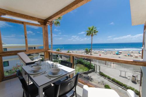 圣阿古斯丁Vv - San Agustín Seaview Apartment的一间设有一张桌子并享有海滩美景的用餐室