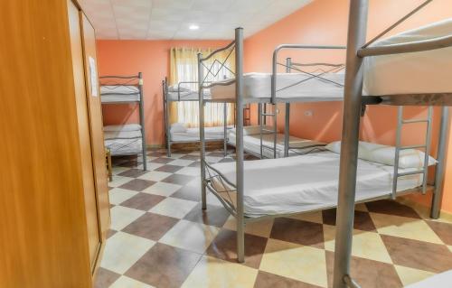 TorremegíaAlbergue Rojo Plata的客房设有三张双层床和一张可拼接的地板。