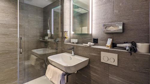 伊瑟尔特瓦尔德斯坦德海滩酒店的一间带水槽和淋浴的浴室