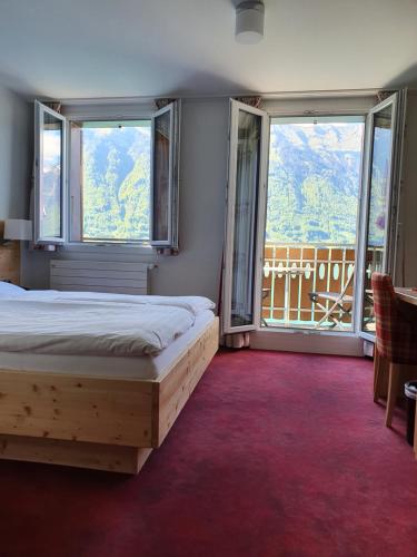 伊瑟尔特瓦尔德斯坦德海滩酒店的一间卧室设有一张床和两个大窗户