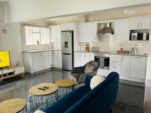 布拉瓦约Remarkable 2-Bed House in Bulawayo的厨房配有白色橱柜、蓝色的沙发和桌子