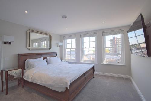 邓斯特布尔Harper Luxe Serviced Apartments Dunstable的卧室配有一张带白色床单和窗户的大床。