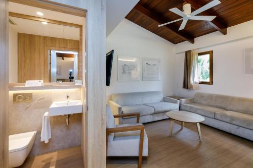 阿尔库迪亚波伦蒂亚蓝色港湾俱乐部Spa度假酒店的带沙发的浴室和带水槽的客厅