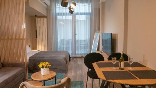 索非亚Луксозно студио One Place in Sofia A1 - Лозенец的酒店客房带两张桌子和一张床