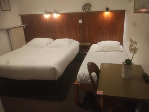 Breuillet努沃莫德酒店的酒店客房设有两张床和一张桌子。