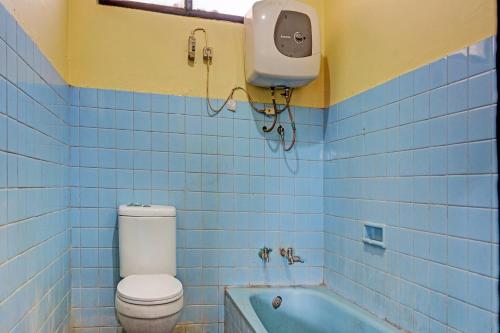 CikampekSPOT ON 91798 Hotel Grand Mutiara的蓝色瓷砖浴室设有卫生间和浴缸