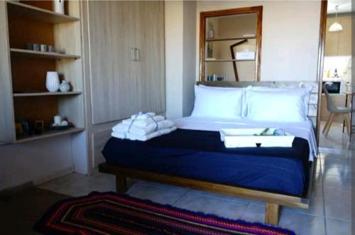 米蒂利尼Havenly Loft的一间卧室配有一张大床,配有蓝色的床单和白色的枕头