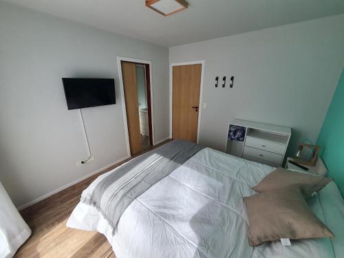 拉安戈斯图拉镇Hygge Haus的一间卧室配有一张大床和一台平面电视