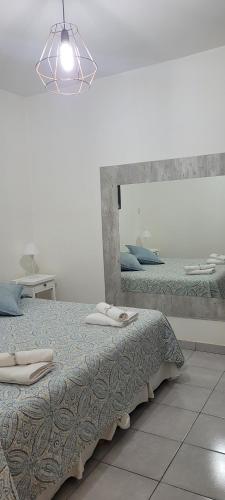 卡塔马卡DEPARTAMENTO A&F II ALQUILER TEMPORARIO的一间卧室设有两张床和大镜子