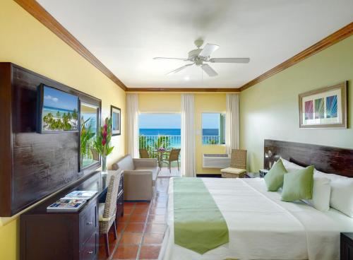 布里奇敦椰子园海滩酒店的酒店客房,配有床和电视