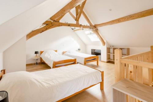 Noyen-sur-SartheMaison d'une chambre avec terrasse amenagee et wifi a Noyen sur Sarthe的木梁客房的两张床