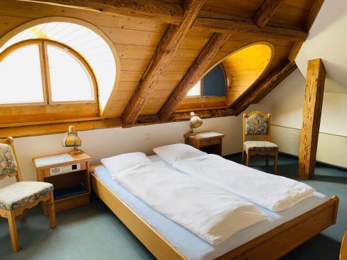 WorbHotel Sternen Worb的一间卧室设有一张大床和两个窗户