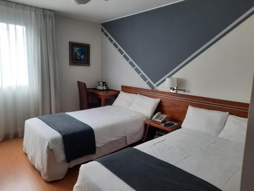 利马伦库米拉弗洛雷斯酒店的酒店客房设有两张床和窗户。