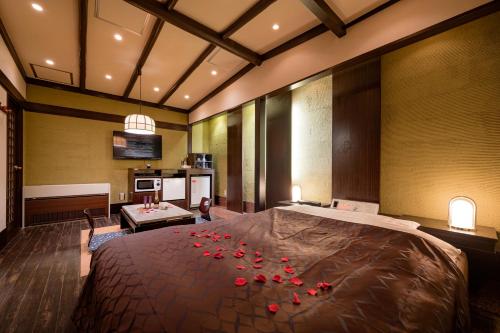 横滨地铁情趣酒店（仅限成人）的一间卧室配有一张大床,上面有红色玫瑰花瓣