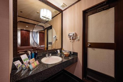 横滨地铁情趣酒店（仅限成人）的一间带水槽和大镜子的浴室