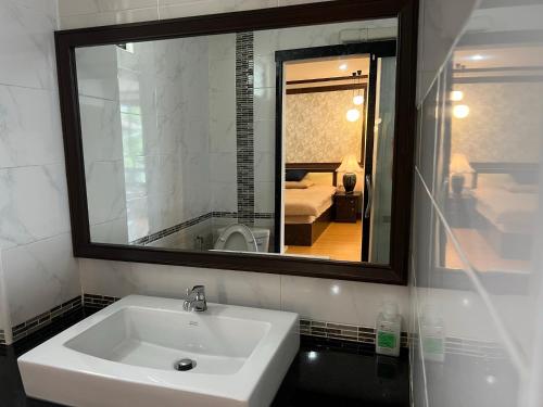 清迈October Hostel ChiangMai的浴室设有白色水槽和镜子