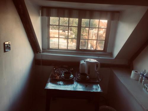 Goffs OakTudor House - Double Room - Shared Bathroom的一张配有微波炉的小桌子和一扇窗户