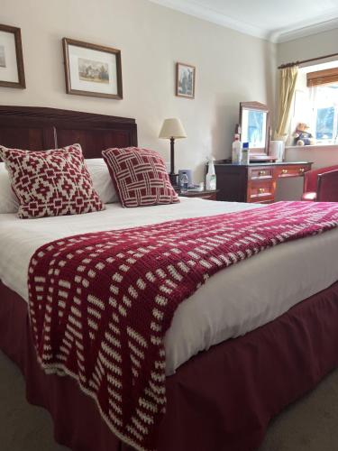 达克斯福德John Barleycorn的一张大床,上面有红白毯子