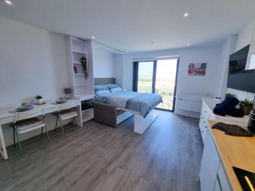 直布罗陀Brand New Top Floor Studio - The Hub Gibraltar - Self Catering的一间卧室配有一张床、一张书桌和一张书桌