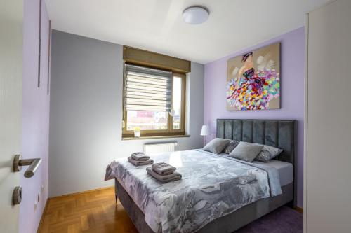 萨格勒布Luxurious apartment in the heart of Zagreb的卧室配有一张床,墙上挂有绘画作品