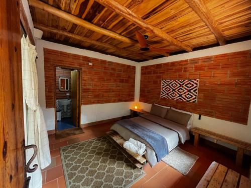 埃尔扎伊诺Origen Hostel的一间卧室设有一张床和砖墙
