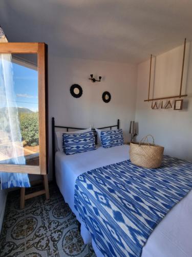 柳奇马约尔Eco Finca Sa Font Blava的一间卧室配有一张带蓝色棉被的床和窗户。