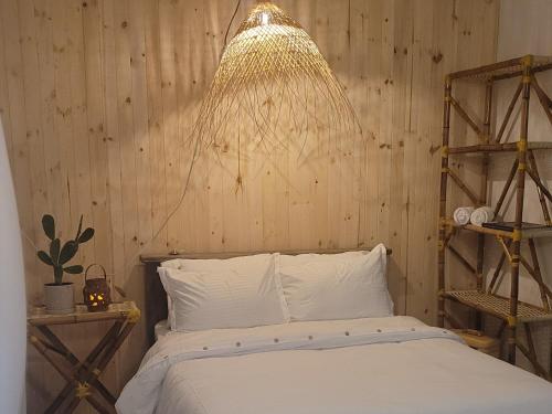 GuarinocitoTuku,的一间卧室配有一张床和一个吊灯