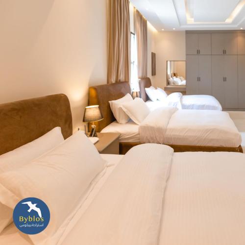 阿尔哈德Byblos Villa Resort的酒店客房,配有3张带白色床单的床