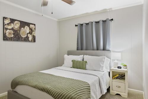 恩特普赖斯Unit 19 Green Acres Apartment的一间白色卧室,配有床和床头柜