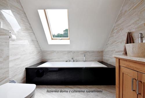 斯托尼拉斯奇Królikówka的带浴缸的浴室和窗户。