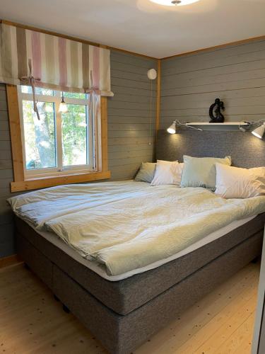TyresöCozy cabin, neighbour to lake & national park的卧室内的一张大床,设有窗户