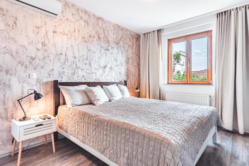 萨格勒布Apartment Zagreb Deluxe的一间卧室设有一张大床和一个窗户。