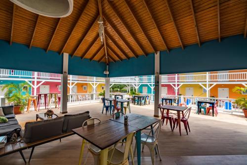 威廉斯塔德Bed & Bike Curacao - Jan Thiel的大型客房配有桌椅和蓝色的墙壁