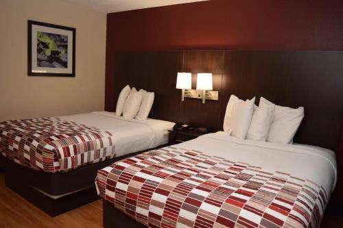 巴达维亚巴达维亚红屋顶酒店的酒店客房设有两张床和两盏灯。