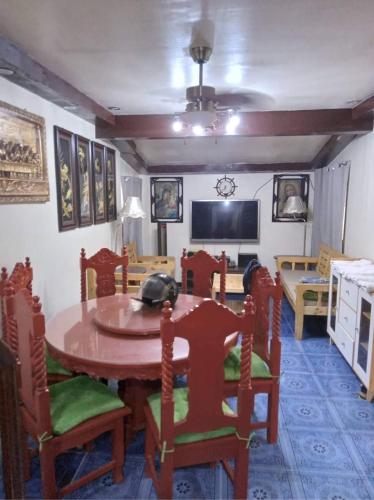 马尼拉Balili Property at Metro Manila Hills Subd Rodriguez Rizal的一间带桌椅和电视的用餐室