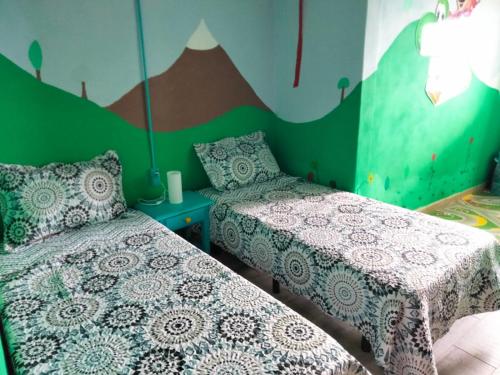 吉亚德伊索拉Casa de Campo Lomo del Balo的一间带两张床和山壁画的卧室