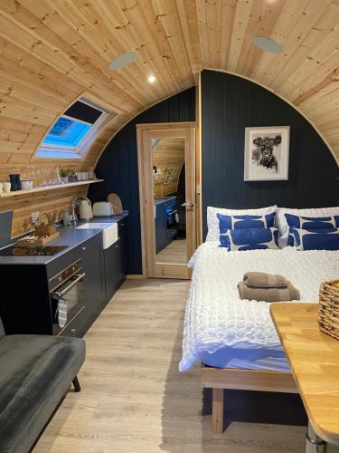 邓弗里斯Craigend Farm Holiday Pods - The Curly Coo的一间卧室设有一张大床和木制天花板