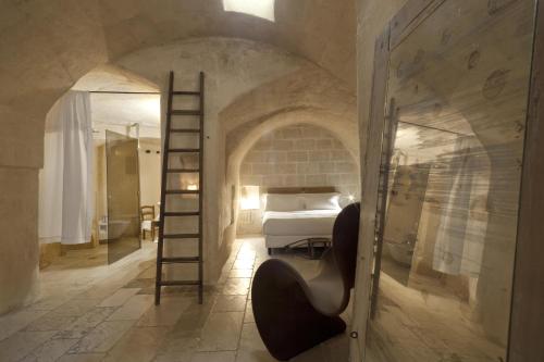 马泰拉科尔特圣彼得酒店的一间卧室,配有梯子和一张位于房间的床