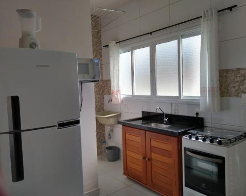 卡拉瓜塔图巴Canto Verde Aptos II的厨房配有白色冰箱和水槽