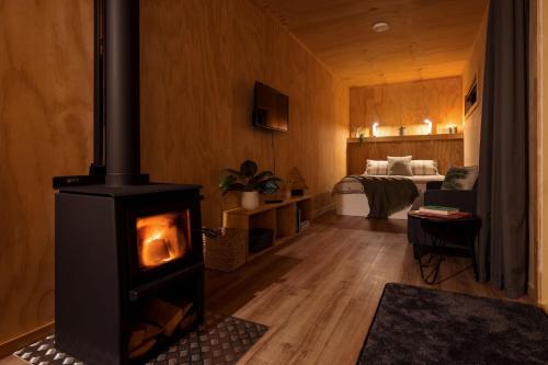 马斯特顿Luxury Container Cabin的一间客厅,客厅内配有燃木炉