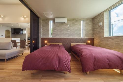屋久岛KeiU-Yakushima Luxury Guest House的带2张床的带客厅的客房
