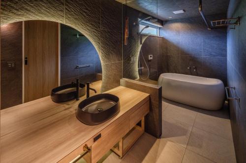 屋久岛KeiU-Yakushima Luxury Guest House的一间带水槽、浴缸和卫生间的浴室