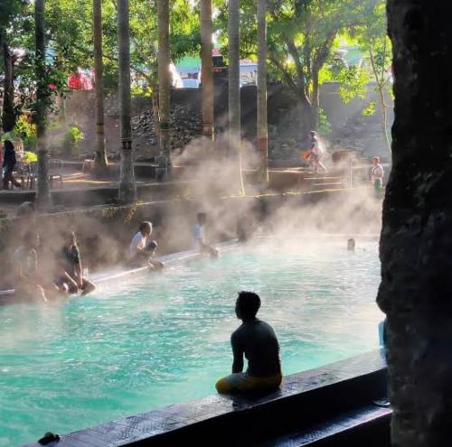 Batu-BatuHakata Lejja near Natural Hot spring的坐在游泳池的水里的人