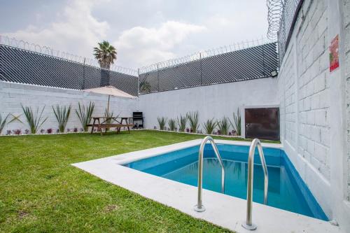 库奥特拉莫雷洛斯Casa con alberca privada y jardin的一座房子后院的游泳池
