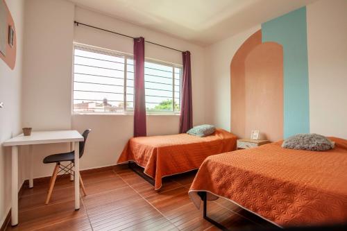 库奥特拉莫雷洛斯Casa con alberca privada y jardin的客房设有两张床、一张桌子和一个窗户。