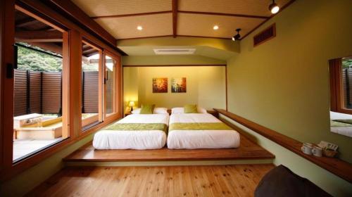 GotsuOWL RESORT ARIFUKU ONSEN的一间卧室设有两张床和大窗户